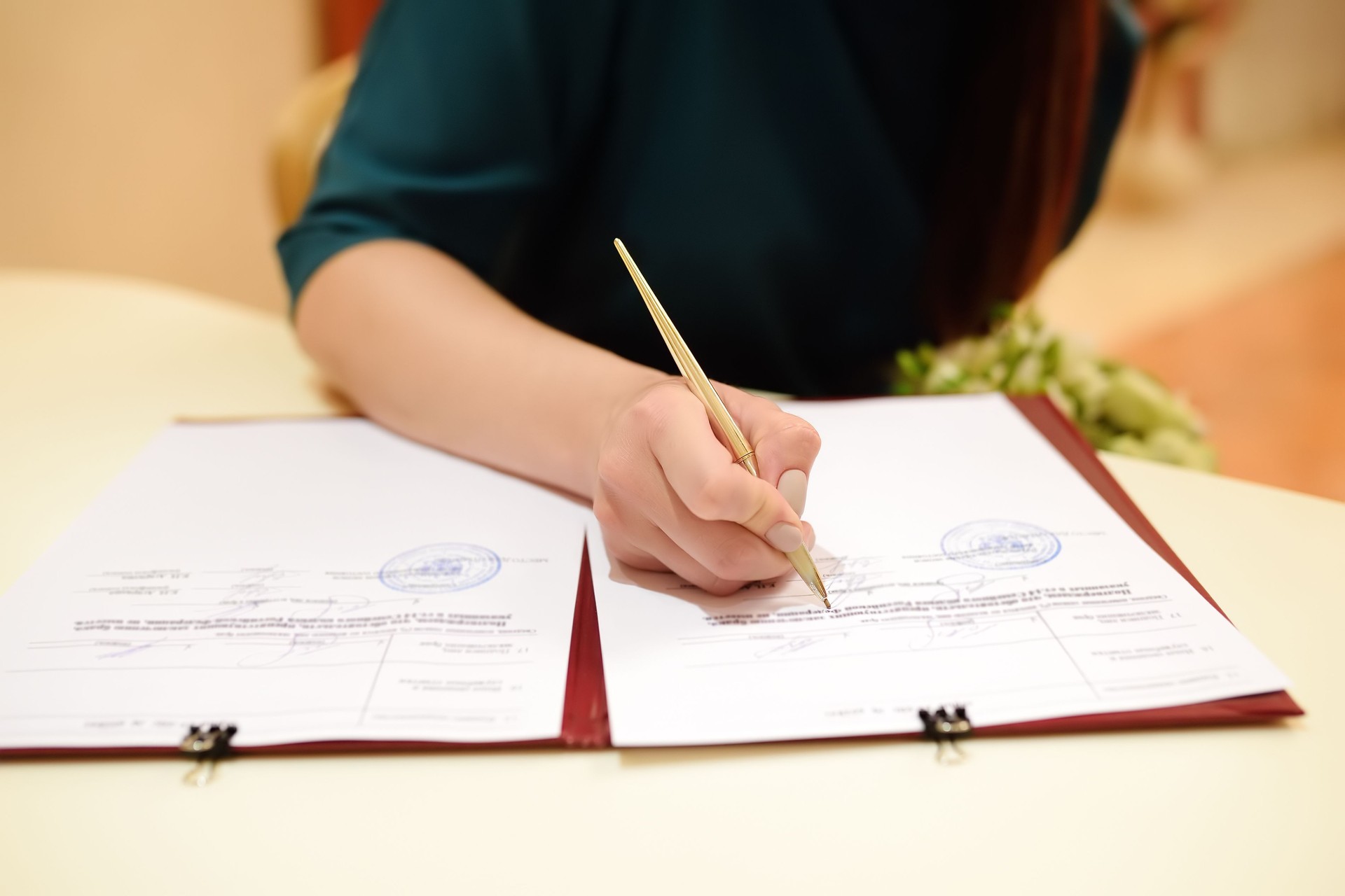 Bride signing marriage license or wedding contract during ceremony